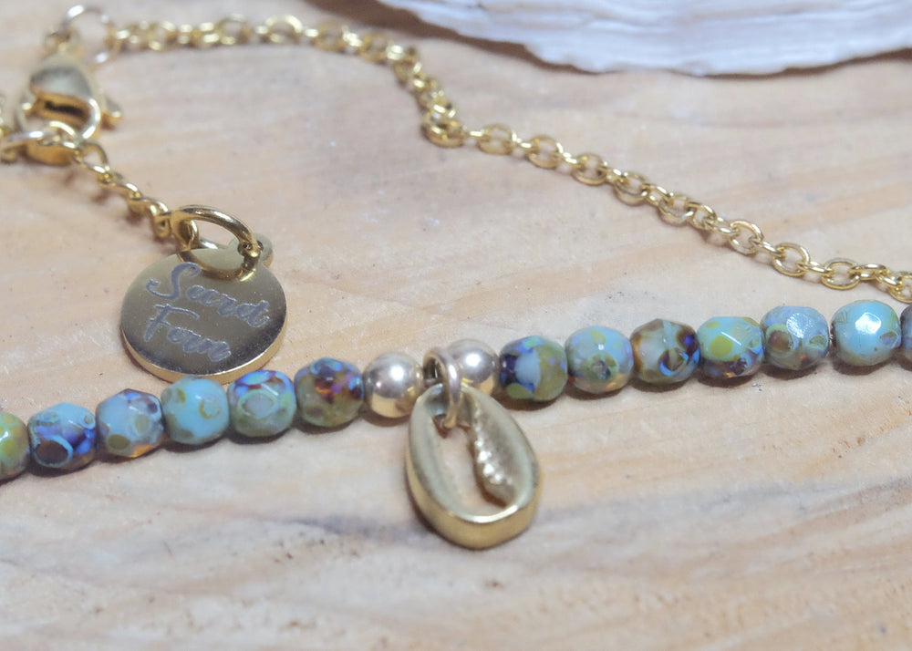 Conch charm anklet on a Gold plated surgical steel chain, tortoise hand fired rustic glass beads, rhinestone charm and gold filled findings.