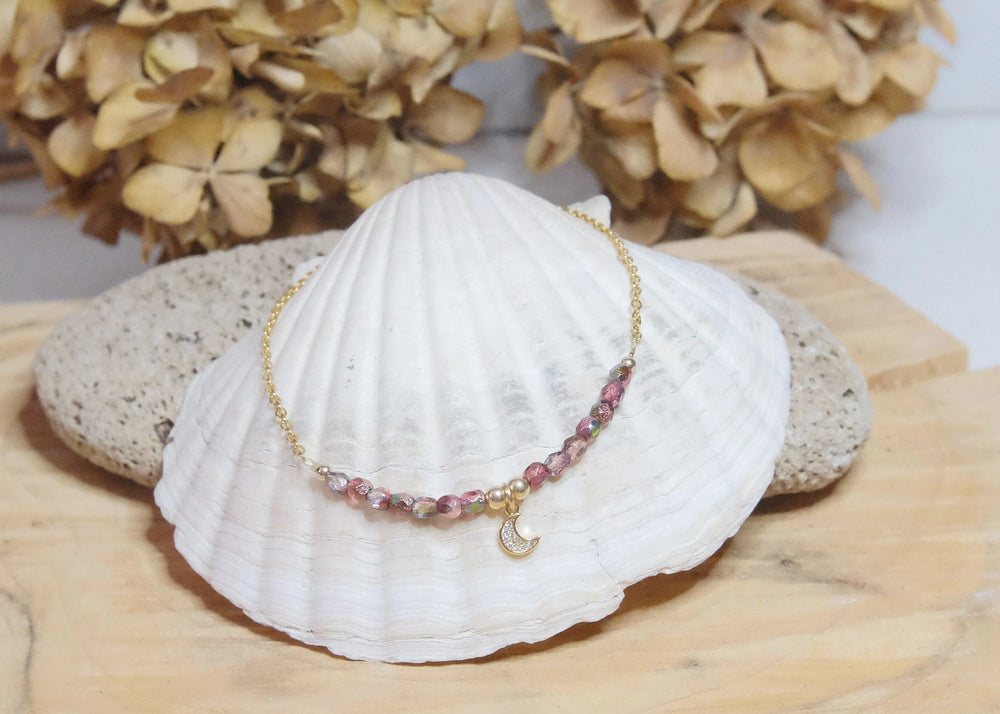 
            
                Load image into Gallery viewer, Raspberry red iridescent rustic glass bead with a rhinestone moon charm anklet on a gold plated s. steel and gold filled elements
            
        