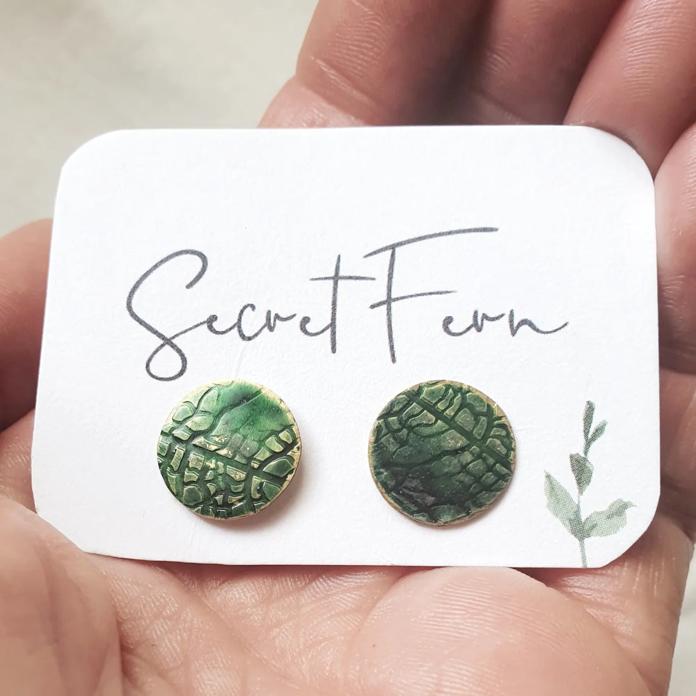 1.3cm round brass disc with leaf imprint and hand-painted in green then sealed. With Sterling silver posts. 