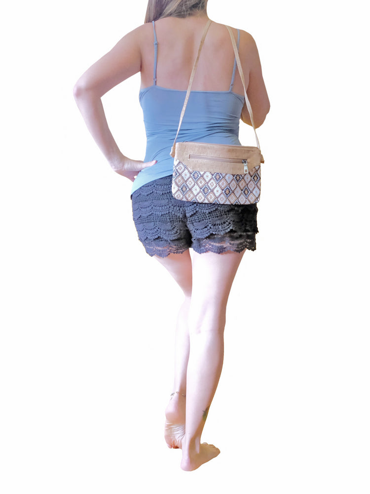 View from the back of a model wearing Triangular boho patterns and cork vegan fabric, this minimalist pouch bag. Made with eco-friendly, sustainable, PETA approved and fair-trade European standards. 