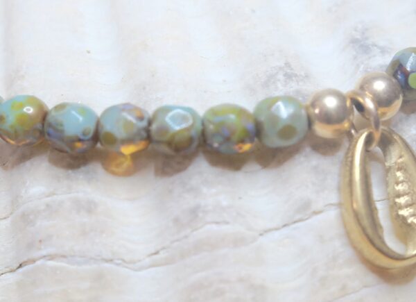 Conch charm anklet on a Gold plated surgical steel chain, tortoise hand fired rustic glass beads, rhinestone charm and gold filled findings.