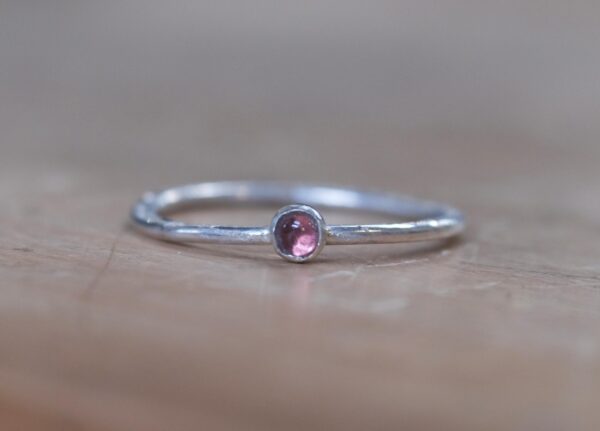 A minimalist sterling silver stacking ring with a natural 3mm pink tourmaline.