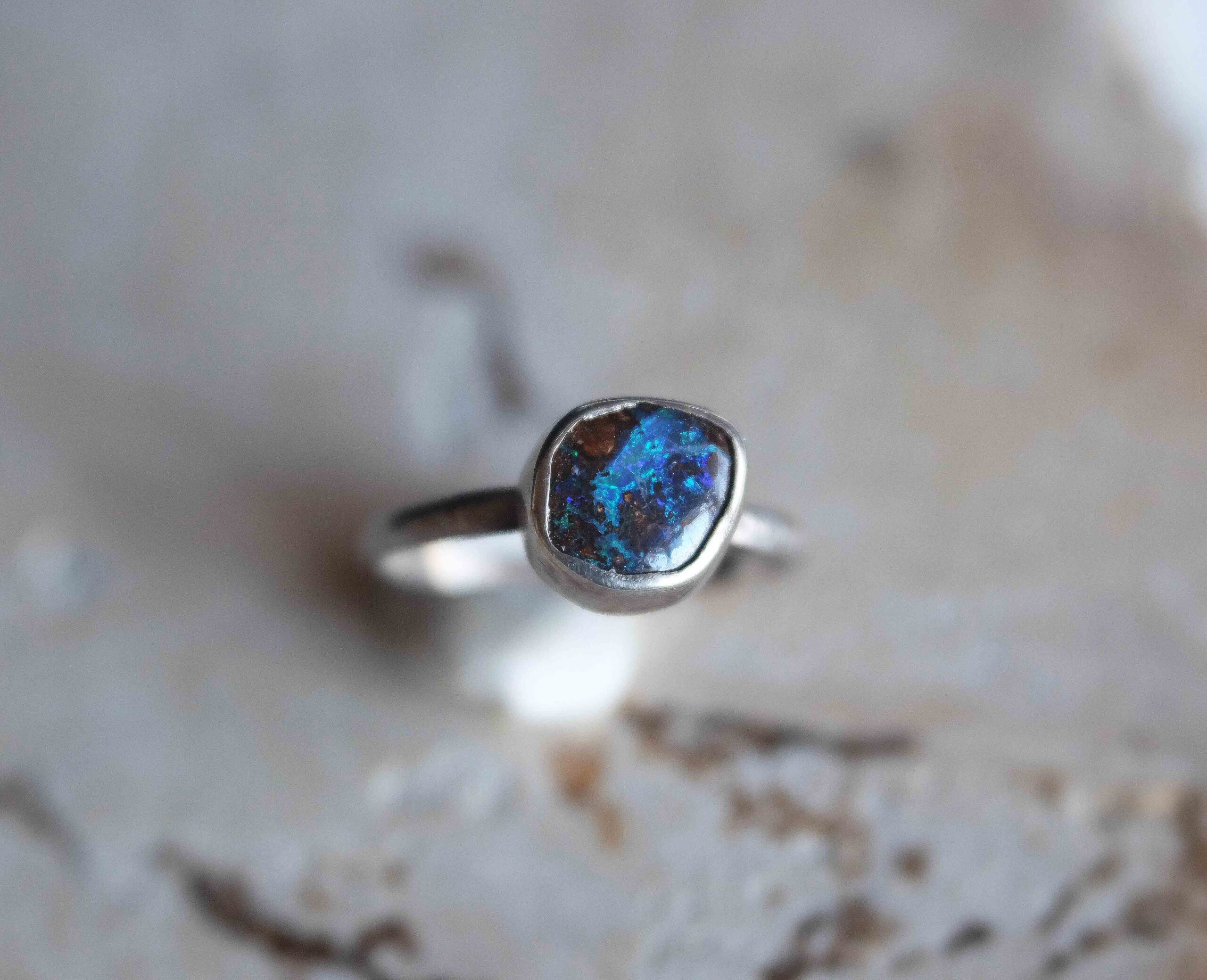 Koroit Opal Ring Handcrafted in my studio, this one-of-a-kind ring features an authentic Australian Koroit opal of 1.45 carats, set in solid sterling silver. This Queensland opal showcases a rich earthy matrix and electric blue and green flashes. This ring is an heirloom and a collector piece.